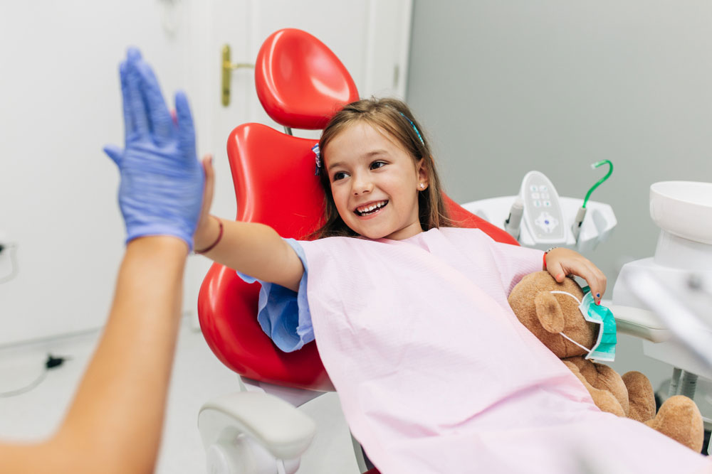 little girl sitting on dental chair and having dental treatment